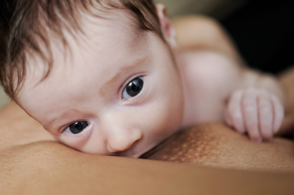 Young mother breastfeeding newborn baby